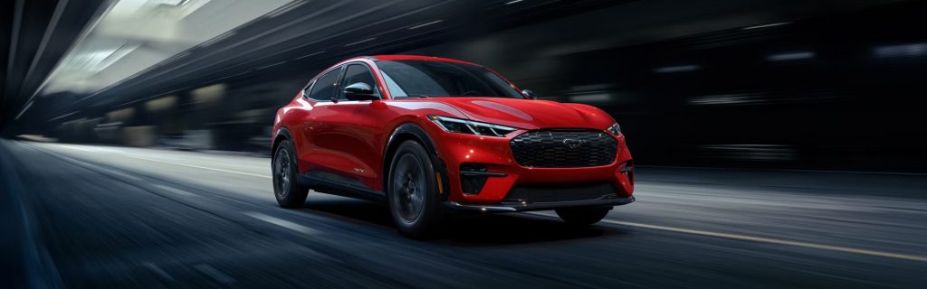 2026 Ford Mustang Mach-E driving fast on a futuristic road